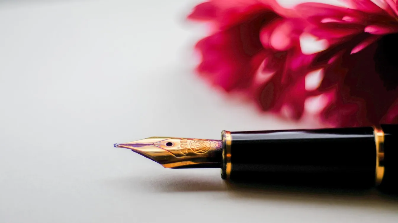 a fountain pen with flowers on top of it