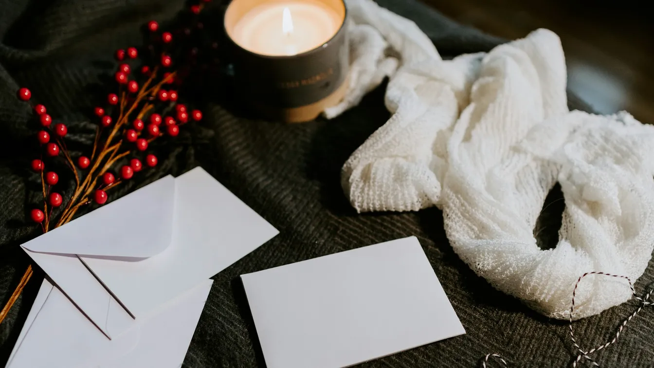 a candle, cards, and berries on a table