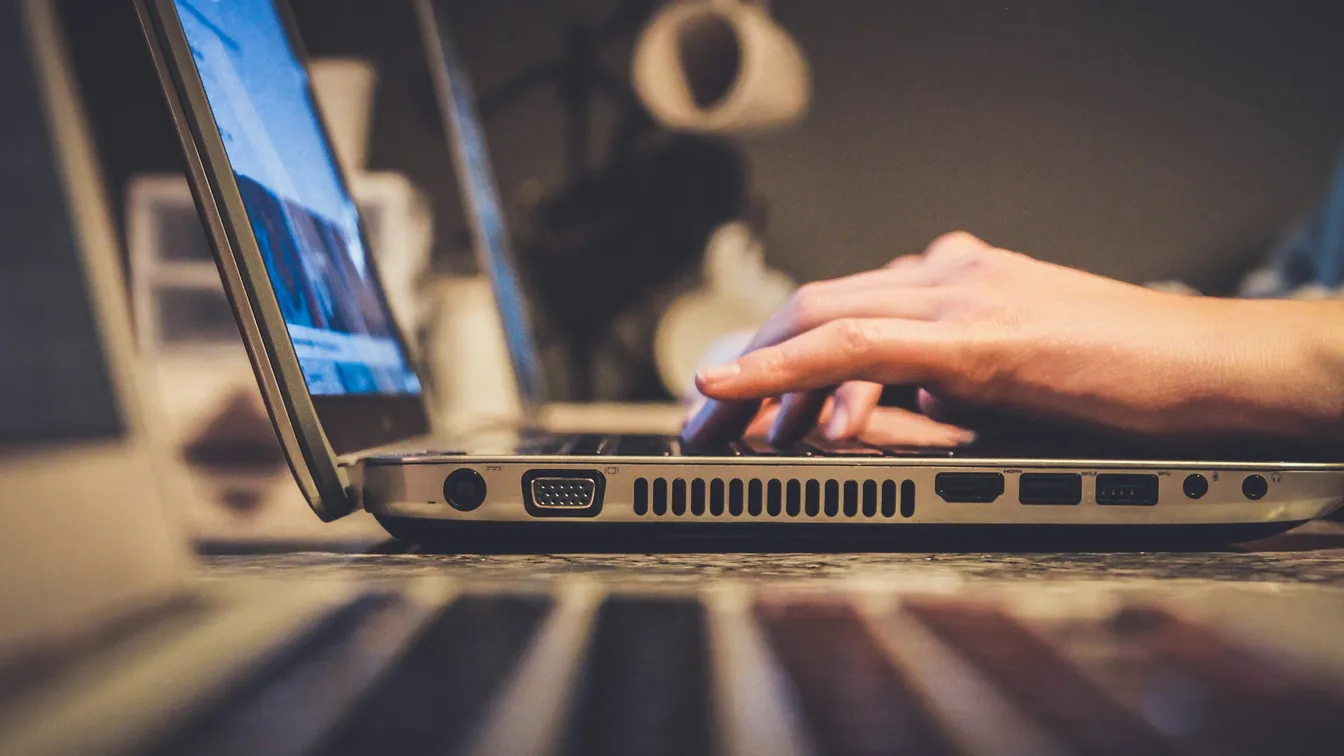 a person typing on a laptop computer