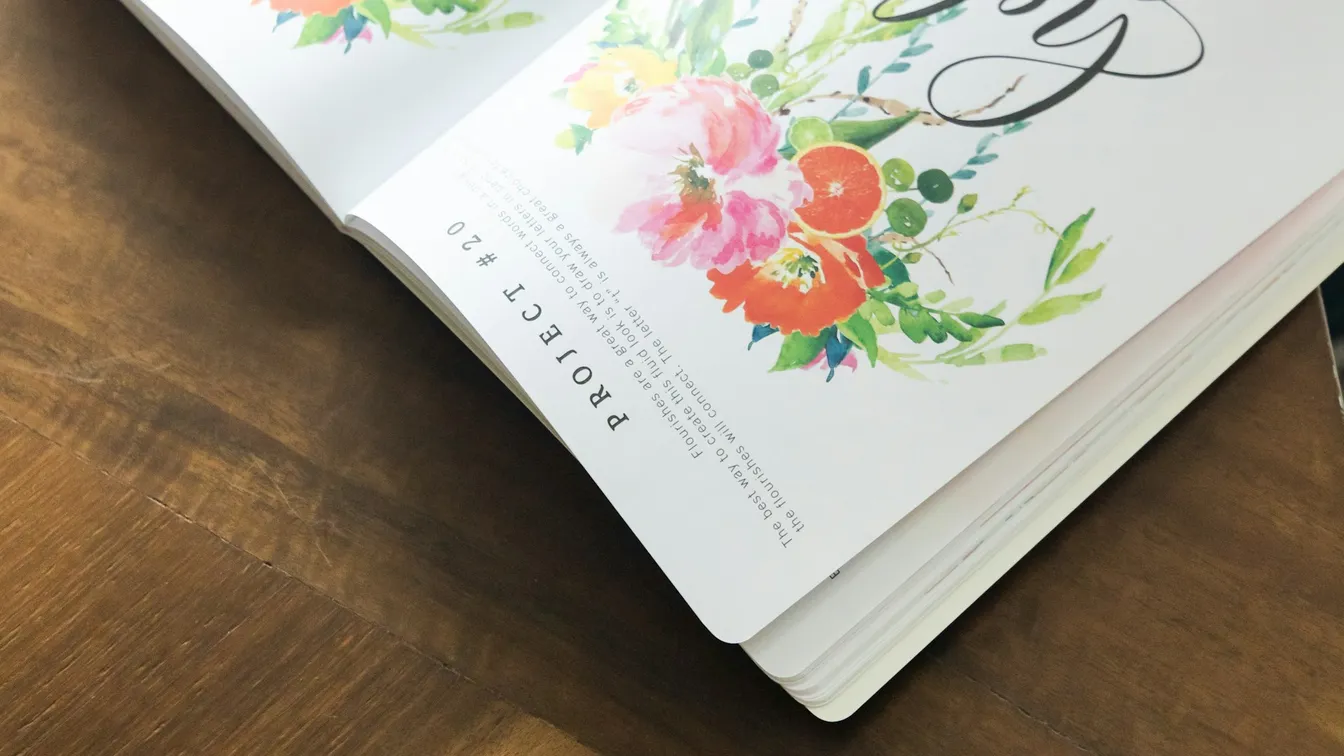 an open book with flowers on it